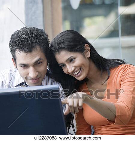 Stock Photo - Close-up of a young couple using a laptop. Fotosearch