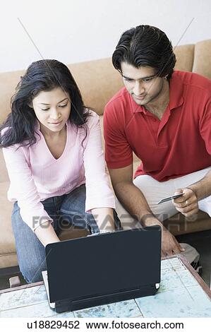 High angle view of a young couple shopping online with a credit card View Large Photo Image Stock Image - High angle view of a young couple shopping online with a credit card. Fotosearch