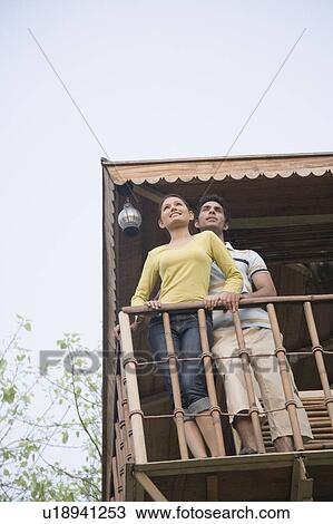 Low angle view of a young couple standing on the beach hut View Large Photo Image Stock Image - Low angle view of a young couple standing on the beach hut. Fotosearch
