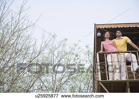 Low angle view of a young couple standing on the beach hut View Large Photo Image Stock Photo - Low angle view of a young couple standing on the beach hut. Fotosearch