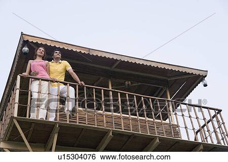 Low angle view of a young couple standing on the beach hut View Large Photo Image Stock Photograph - Low angle view of a young couple standing on the beach hut. Fotosearch