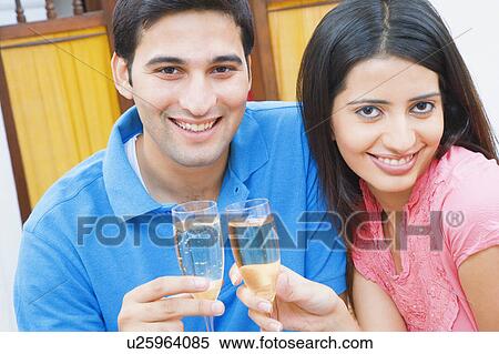 Portrait of a young couple toasting with champagne flutes View Large Photo Image Stock Photography - Portrait of a young couple toasting with champagne flutes. Fotosearch