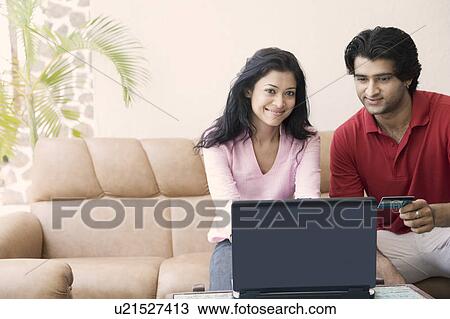 Stock Image - Young couple shopping online with a credit card. Fotosearch