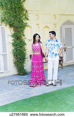Young couple walking with holding their hands and smiling View Large Photo Image Stock Photography - Young couple walking with holding their hands and smiling. Fotosearch