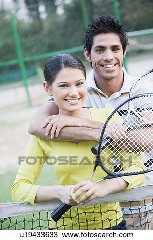 Young man embracing a young woman from behind in a tennis court View Large Photo Image Stock Image - Young man embracing a young woman from behind in a tennis court. Fotosearch