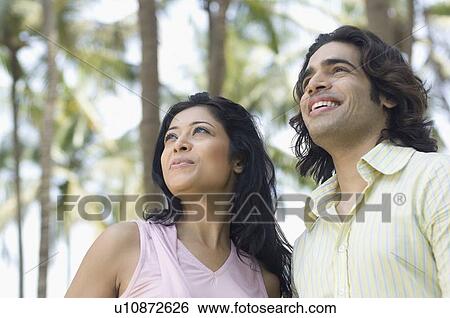 Close-up of a young couple smiling View Large Photo Image Stock Photograph - Close-up of a young couple smiling. Fotosearch