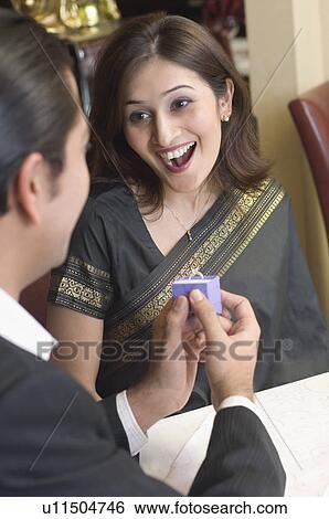 Mid adult man proposing a young woman View Large Photo Image Stock Photograph - Mid adult man proposing a young woman. Fotosearch