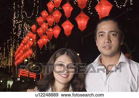 Portrait of a mid adult man with his arm around a young woman and smiling View Large Photo Image Stock Photo - Portrait of a mid adult man with his arm around a young woman and smiling. Fotosearch