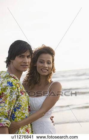 Stock Image - Portrait of a young couple embracing each other. Fotosearch