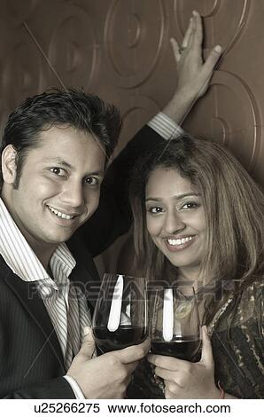 Portrait of a young couple holding glasses of wine View Large Photo Image Stock Photography - Portrait of a young couple holding glasses of wine. Fotosearch