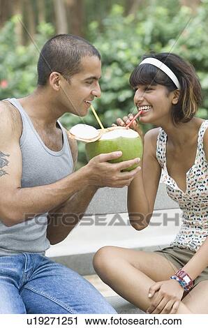 Young couple drinking coconut milk and smiling View Large Photo Image Stock Image - Young couple drinking coconut milk and smiling. Fotosearch