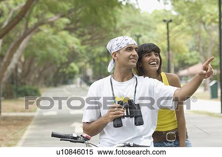 Young couple riding a bicycle and smiling View Large Photo Image Stock Photography - Young couple riding a bicycle and smiling. Fotosearch