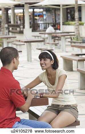 Stock Photo - Young couple sitting in a sidewalk cafe. Fotosearch