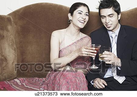 Young couple toasting with martini and whiskey glasses View Large Photo Image Stock Image - Young couple toasting with martini and whiskey glasses. Fotosearch