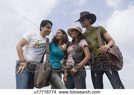 Picture - Low angle view of two young couples standing together and smiling. Fotosearch
