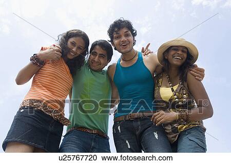 Low angle view of two young couples standing together and smiling View Large Photo Image Stock Image - Low angle view of two young couples standing together and smiling. Fotosearch