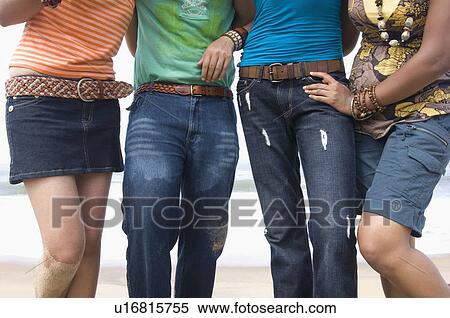 Mid section view of two young couples standing together on the beach View Large Photo Image Stock Photography - Mid section view of two young couples standing together on the beach. Fotosearch