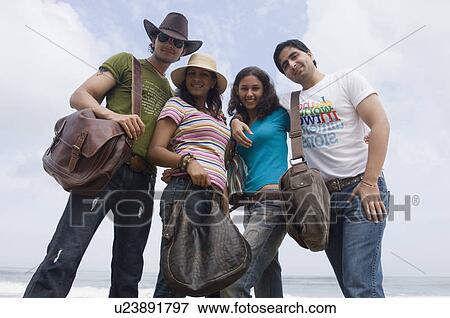 Portrait of two young couples standing on the beach and smiling View Large Photo Image Stock Photo - Portrait of two young couples standing on the beach and smiling. Fotosearch