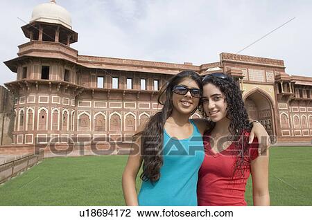 Stock Image - Portrait of two young women standing together and smiling, Taj Mahal, Agra, Uttar Pradesh, India. Fotosearch