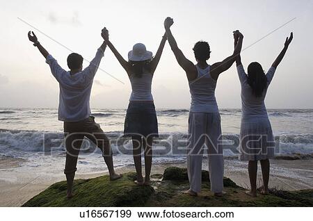 Rear view of two young couples standing together View Large Photo Image Stock Photo - Rear view of two young couples standing together. Fotosearch