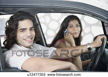 Close-up of a young couple sitting in a car and smiling View Large Photo Image Stock Image - Close-up of a young couple sitting in a car and smiling. Fotosearch