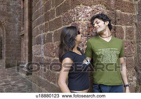 Stock Image - Young couple looking at each other and smiling, Goa, India. Fotosearch