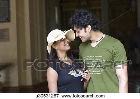 Stock Photo - Young couple looking at each other and smiling, Goa, India. Fotosearch