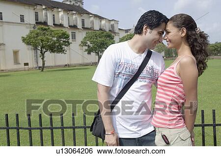 Young couple looking at each other and smiling, Se Cathedral, Goa, India View Large Photo Image Stock Photograph - Young couple looking at each other and smiling, Se Cathedral, Goa, India. Fotosearch