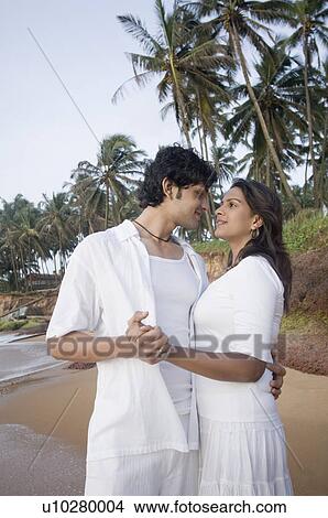 Picture - Young couple romancing on the beach, Goa, India. Fotosearch