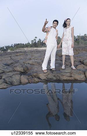 Young couple standing on rocks and holding their hands View Large Photo Image Stock Photography - Young couple standing on rocks and holding their hands. Fotosearch
