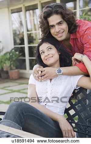 Picture - Young man with his arm around a young woman. Fotosearch