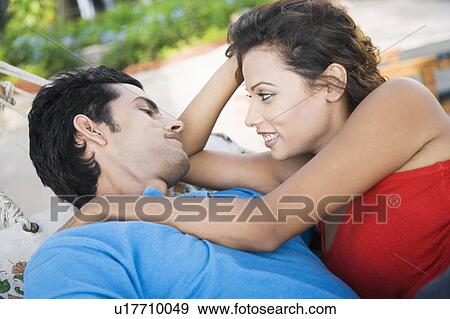 Stock Photo - Close-up of a young couple lying in a hammock and looking at each other. Fotosearch