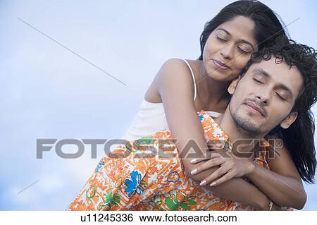 Close-up of a young woman riding piggyback on a young man View Large Photo Image Stock Photograph - Close-up of a young woman riding piggyback on a young man. Fotosearch