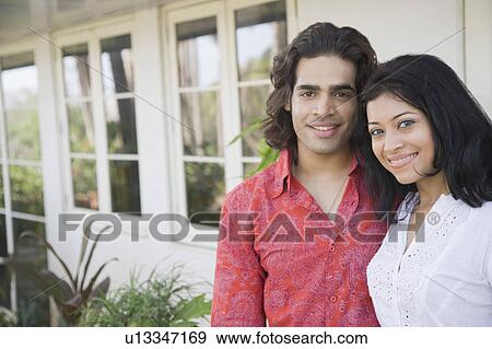 Portrait of a young couple smiling and standing together View Large Photo Image Stock Photo - Portrait of a young couple smiling and standing together. Fotosearch