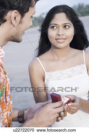 Side profile of a young man gifting a ring to a young woman View Large Photo Image Stock Image - Side profile of a young man gifting a ring to a young woman. Fotosearch