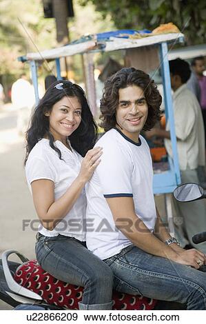 Young couple sitting on a motorcycle View Large Photo Image Stock Photo - Young couple sitting on a motorcycle. Fotosearch