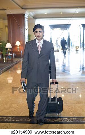 Businessman walking with a luggage View Large Photo Image Stock Photo - Businessman walking with a luggage. Fotosearch