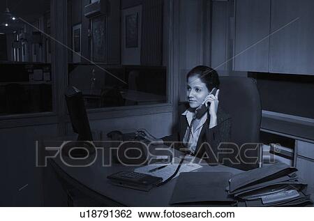 Businesswoman talking on the telephone in an office View Large Photo Image Stock Image - Businesswoman talking on the telephone in an office. Fotosearch