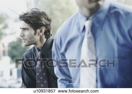 Stock Photo - Close-up of two businessmen looking sideways. Fotosearch