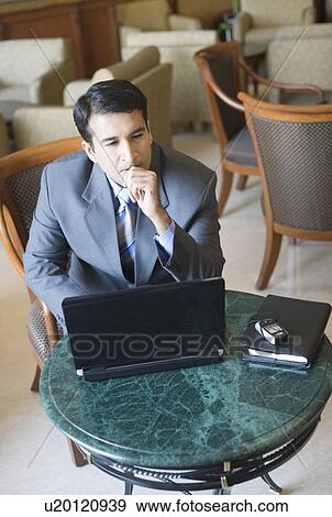 High angle view of a businessman sitting in an armchair and thinking View Large Photo Image Stock Photo - High angle view of a businessman sitting in an armchair and thinking. Fotosearch