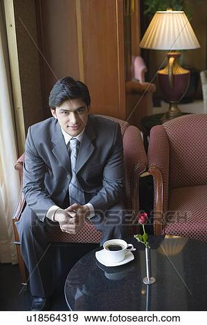 Portrait of a businessman sitting in an armchair and smirking View Large Photo Image Stock Photo - Portrait of a businessman sitting in an armchair and smirking. Fotosearch