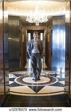 Portrait of a businessman walking with his hands in his pockets View Large Photo Image Stock Image - Portrait of a businessman walking with his hands in his pockets. Fotosearch