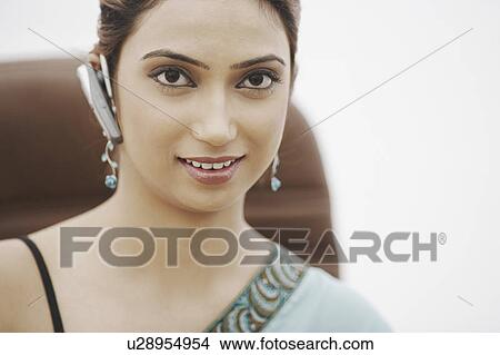 Picture - Portrait of a businesswoman wearing a hands free device in her ear. Fotosearch