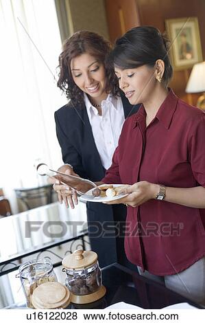 Two businesswomen having food View Large Photo Image Stock Photo - Two businesswomen having food. Fotosearch