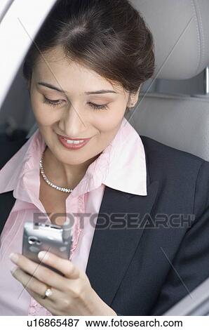Businesswoman operating a mobile phone View Large Photo Image Stock Photo - Businesswoman operating a mobile phone. Fotosearch