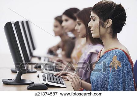 Close-up of four businesswomen sitting in front of computers View Large Photo Image Stock Photo - Close-up of four businesswomen sitting in front of computers. Fotosearch