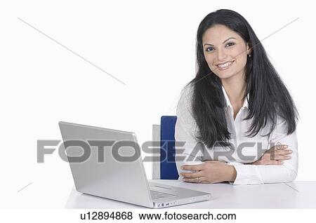 Portrait of a businesswoman sitting in front of a laptop View Large Photo Image Stock Photo - Portrait of a businesswoman sitting in front of a laptop. Fotosearch