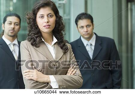 Portrait of a businesswoman with two businessmen standing behind her View Large Photo Image Picture - Portrait of a businesswoman with two businessmen standing behind her. Fotosearch