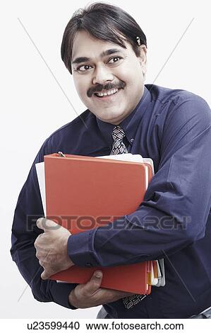 Close-up of a businessman holding a stack of files View Large Photo Image Stock Image - Close-up of a businessman holding a stack of files. Fotosearch
