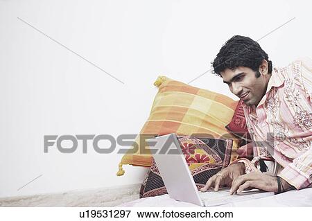 Close-up of a young man working on a laptop View Large Photo Image Stock Photo - Close-up of a young man working on a laptop. Fotosearch